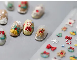 Macro shot of 3D Christmas nail stickers with embossed gingerbread and snowflake patterns