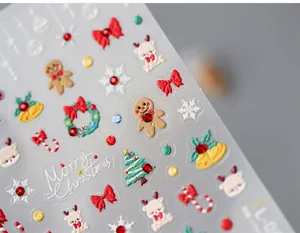 Macro detail of 3D embossed Christmas nail stickers with reindeer and ginger bread man motifs