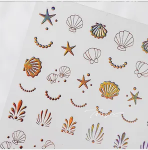 Détails macro d'autocollants nail art nacrés en relief avec coquillages et étoiles de mer