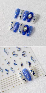 Close-up of 5D blue and white marble nail stickers with rhinestones and gold star accents