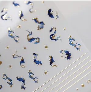 Macro shot of blue marble nail stickers with 5D gold embossed edges and star patterns