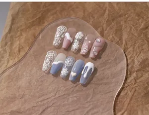 Close-up of 3D embossed Christmas press-on nails with snowflakes and gingerbread patterns