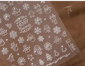 Macro detail of 3D silver Christmas nail stickers with pearl accents and reindeer patterns