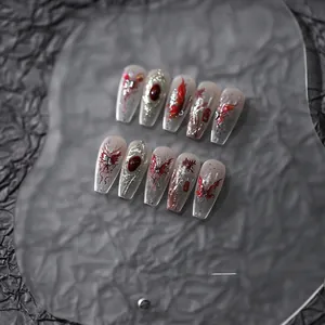 Macro detail of long coffin nails with 3D gothic butterfly relief and red gems