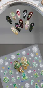 Macro shot of 3D embossed Christmas nail stickers featuring green trees and gold glitter bow