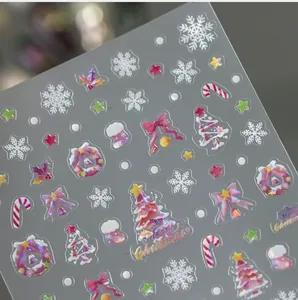 Macro shot of 3D Christmas nail stickers with gold Merry Christmas lettering and glitter