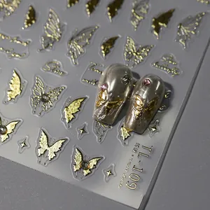 3D Schmetterling Nailart Aufkleber mit Goldrelief Effekt auf grauen Kunstnägeln