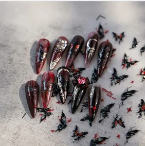 Close-up of Gothic butterfly nail art stickers with 5D embossed red and black patterns