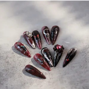 Detailed view of handmade gothic press-on nails with butterfly and spider motifs