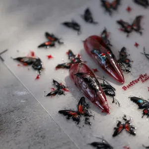 Close-up of 5D embossed butterfly nail stickers with realistic dark red and black patterns