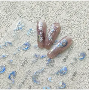 Detail of silver laser dragon and phoenix nail stickers on translucent pink nail tips