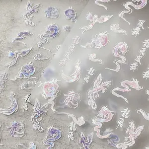 Detail of holographic dragon and phoenix nail stickers with shimmering metallic texture