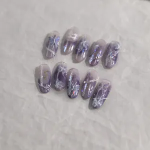 Detailed view of purple gradient press-on nails with butterfly motifs and sequins