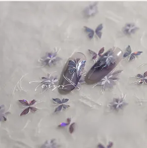 Macro shot of purple butterfly nail decals with white flowers and gold stamping details