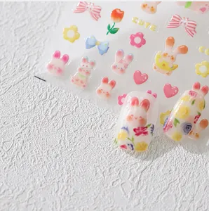 Primer plano de pegatinas de uñas en relieve 3D con conejitos y motivos de flores
