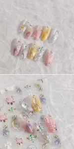 Detailed view of koi fish nail art stickers with gold foil and 3D pearls on pink nails