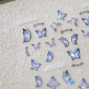 Macro detail of holographic purple and blue butterfly nail art stickers with foil accents