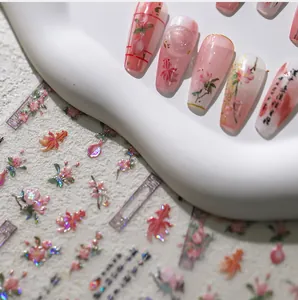 Macro view of Chinese style pink nail stickers featuring goldfish and floral motifs