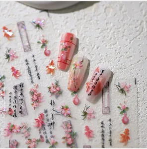 Detail view of floral nail stickers with pink plum blossoms and golden fish patterns