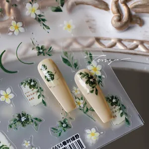 Macro detail of floral nail art stickers with green leaves on nude almond shaped nails