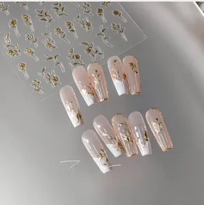 Detail of M-332 nail stickers featuring gold floral patterns on French tip nails