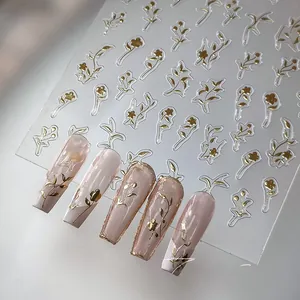Detail of M-332 3D gold flower nail stickers applied on elegant nude manicured nails