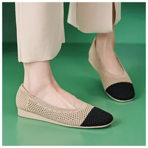 Detail von klassischen beigen Strick-Ballerinas mit schwarzer Kontrastkappe am Modell