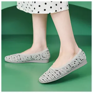 Side view of comfortable grey knitted flat shoes for women with breathable mesh texture