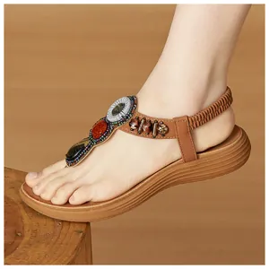 Close-up of Bohemian brown wedge sandals with colorful gemstones and retro wood beads