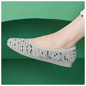 Side view of grey knit flat shoes with striped texture on a modern curved background