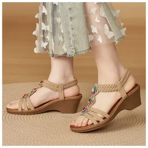Détail de sandales compensées bohèmes avec perles colorées et strass sur la bride en T