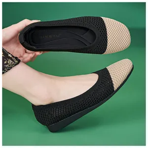 Detail der gestrickten flachen Schuhe mit atmungsaktivem Mesh und Beige-Schwarz-Kontrast