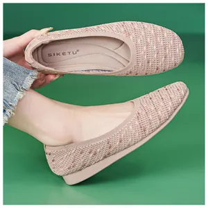 Detail shot of soft pink knit flat shoes showing flexible sole and brand logo
