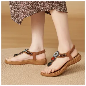 Detail of bohemian T-strap sandals with colorful beads and sequins on elastic heel strap