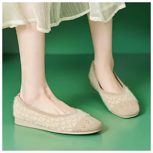Close-up of beige knit ballet flats with textured patterns and soft faux fur trim detail