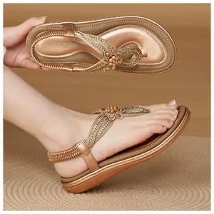 Detail of bohemian gold wedge sandals featuring rhinestone flowers and elastic back strap