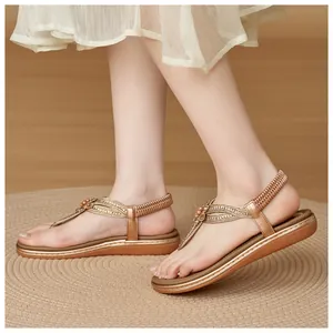 Detailed view of rose gold bohemian flat sandals with rhinestone flowers and elastic heel strap