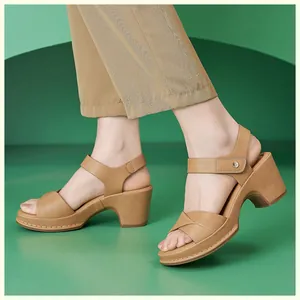 Detailed close-up of brown cross-strap chunky heel sandals with hook-and-loop ankle straps