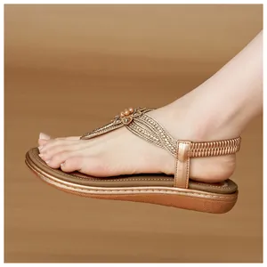 Detail of bohemian rose gold wedge sandals featuring floral beads and elastic heel strap