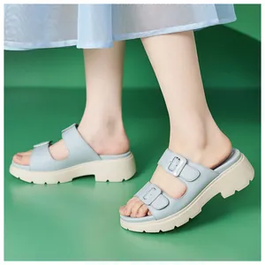 Nahaufnahme hellblauer Plateau-Sandalen mit doppelten Riemen und dekorativen Schnallen