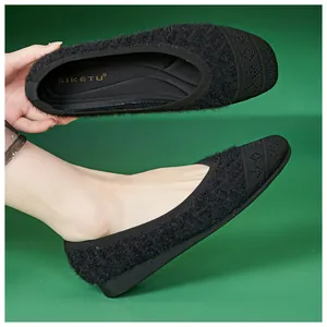 Detail of plush black loafers with knitted rhombus pattern toe and soft inner sole