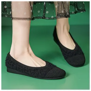Detail of black faux fur flat shoes with knit texture and geometric woven patterns