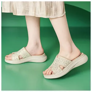 Detail van beige platform sleehakken met H-vormige band en strass steentjes op model