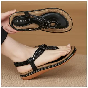 Detail of beaded flower decoration and elastic back strap on flat bohemian sandals