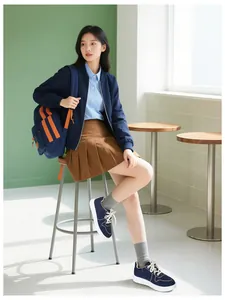 Full view of women's lightweight navy sneakers styled with a pleated skirt and backpack