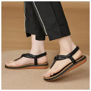 Close-up of bohemian T-strap sandals with rhinestone flower details and elastic heel strap