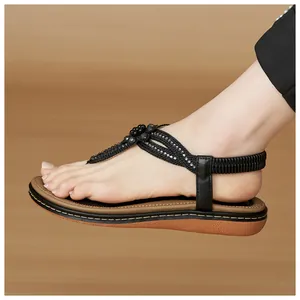 Detail of bohemian black T-strap sandals with rhinestone floral beadwork and elastic back strap