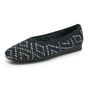 Detail of black knitted flat shoes featuring colorful stitch patterns and breathable texture