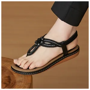 Detail of bohemian T-strap sandals with rhinestones and flower beads on braided straps