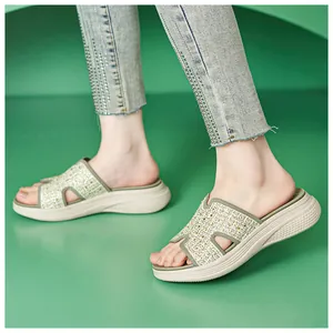 Detail van dames plateau slippers met groene bies en sprankelende strassteentjes